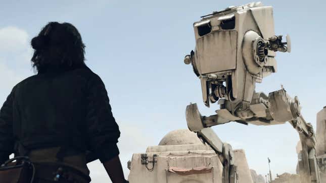 An image shows a woman in shadow looking up at a large AT-ST. 