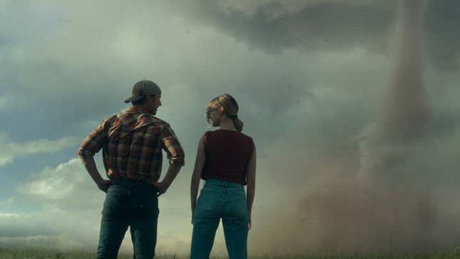 Glen Powell and Daisy Edgar-Jones stand in front of a tornado. 